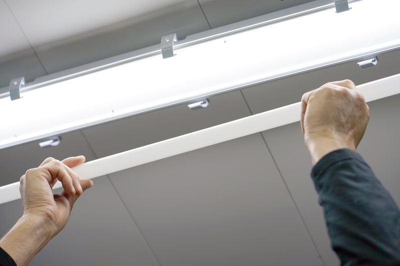 _electric_hands_changing_ceiling_fluorescent_lamp._the_concept_of_repair_and_service.jpg